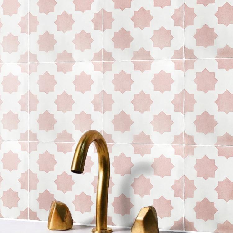 Pink hand painted tiles with a star design styled with a modern brass tap