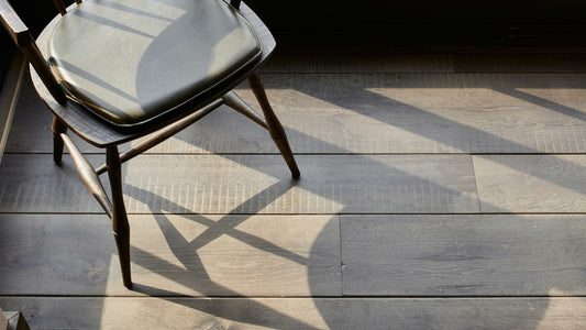 Engineered wood floor with sunlight illuminating it and a vent wood chair 