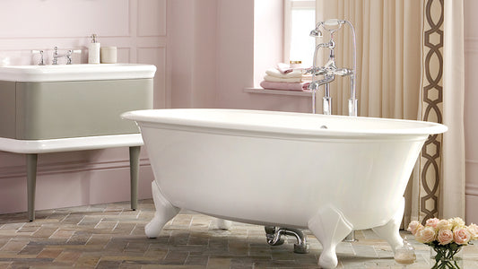 Freestanding roll top bath with claw feet in a pink painted bathroom