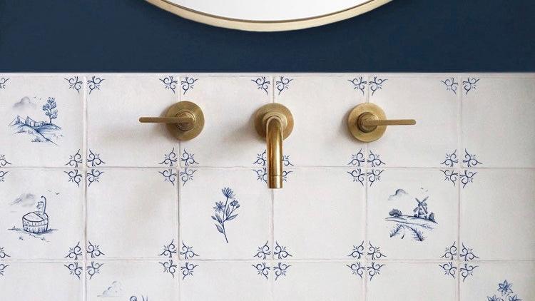 Delft tiles in a stylish bathroom with brass wall-mounted taps 