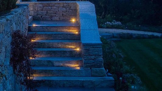 Outdoor solid brass step lights in landscaped garden 
