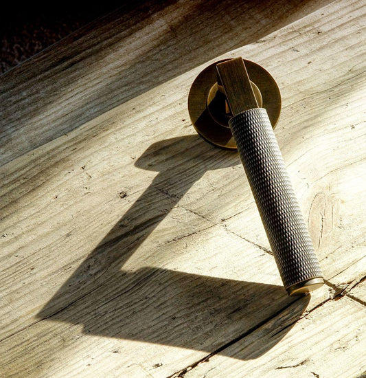 Knurled brass door handle on a wooden worktop