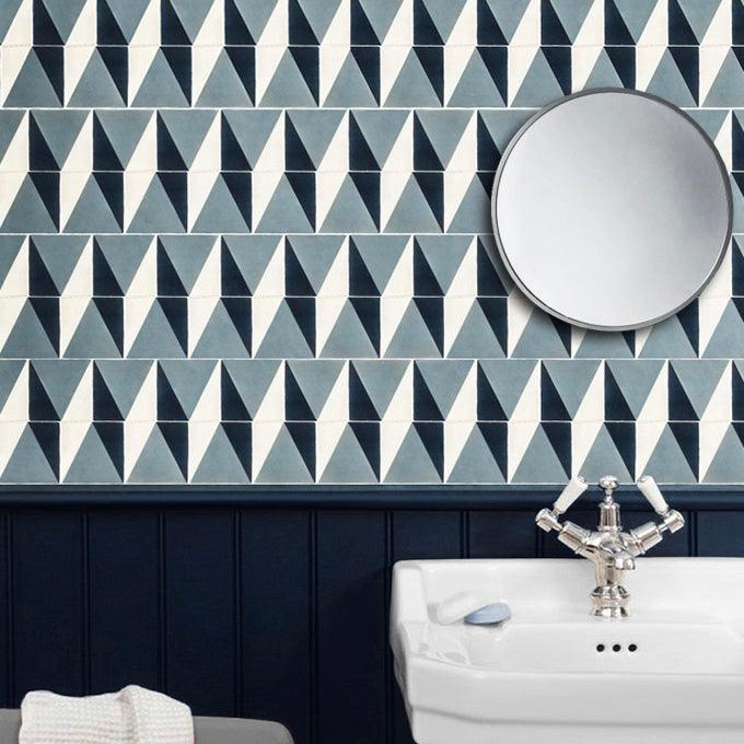 Geometric tiles styled in a stylish bathroom lplaced behind a freestanding basin with circular mirror